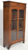 A 1920's oak bookcase display cabinet. The golden oak upright cabinet with twin glazed doors housing