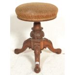 A Victorian 19th Century mahogany revolving piano stool raised on a splayed leg base having carved