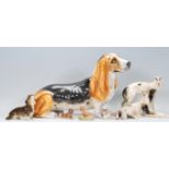 A collection of ceramic dog figurines to include a basset hound, two lurcher figurines marked RS,