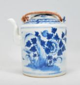 A 19th Century Chinese porcelain tea pot of tubular form hand painted in blue and white with peonies