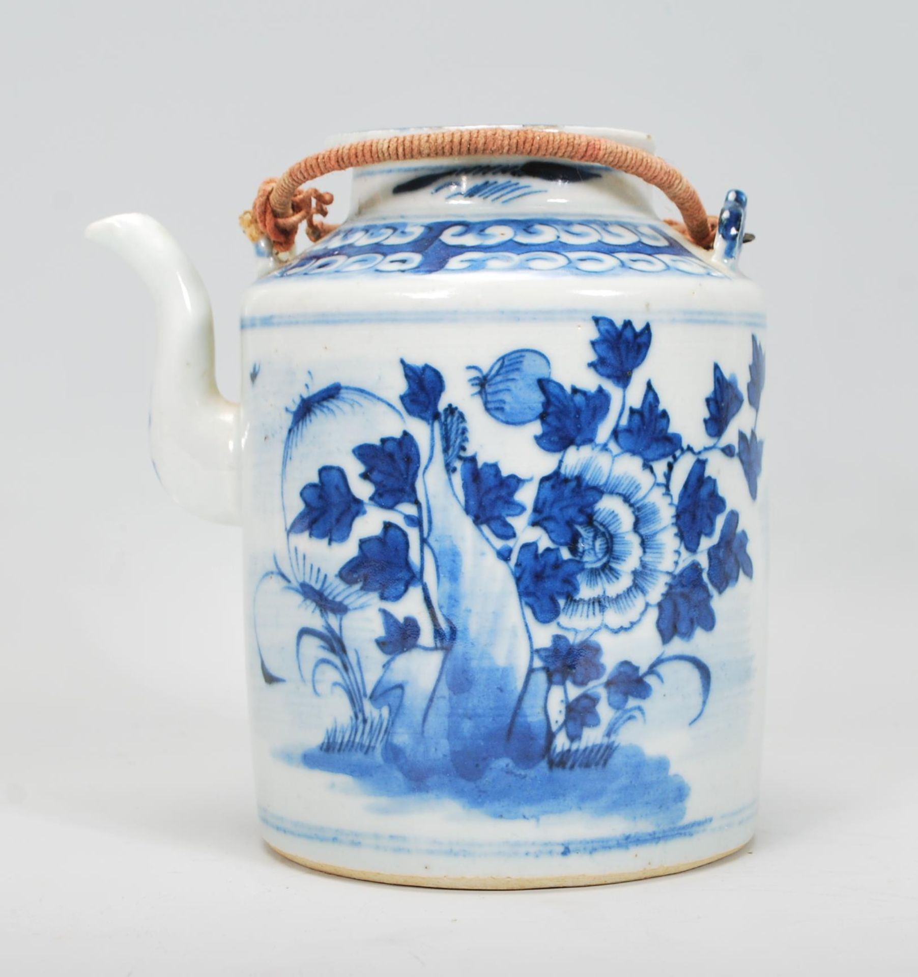 A 19th Century Chinese porcelain tea pot of tubular form hand painted in blue and white with peonies