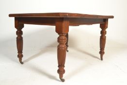 A Victorian 19th century mahogany wind out extending table. Raised on ceramic brown castors with