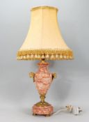 A 20th century Adams revival red and white ripple marble veined table lamp with gilded feet and rams