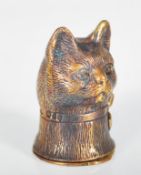 A detailed brass vesta case in the form of a cat wearing a bow having match striker to base.