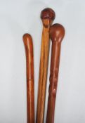 A group of three 20th Century carved wooden walking stick canes to include one carved with into a