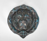 A large statement cast iron lion mask door knocker of round form having embossed lion mask to the