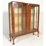 A 1930s  Queen Anne revival walnut serpentine-front display china cabinet, with two glazed doors,