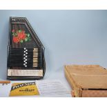 A vintage 20th Century boxed Auto-Harp having an ebonised body with painted flower decoration. Paper