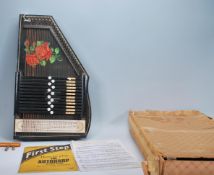 A vintage 20th Century boxed Auto-Harp having an ebonised body with painted flower decoration. Paper