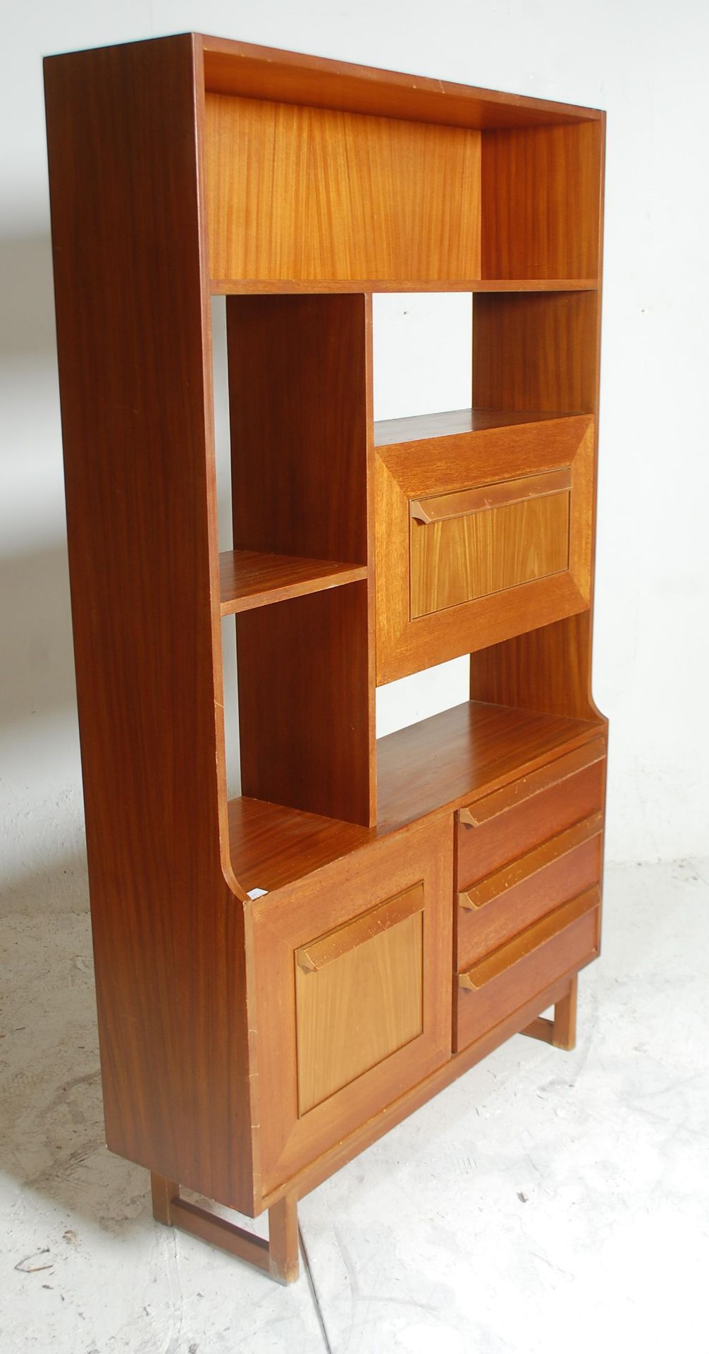 A retro mid 20th Century teak wood room unit having fitted shelves above a configuration of three