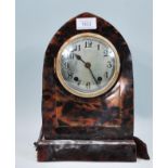 An early 20th Century faux tortoise shell bakelite mantel clock of domed form having a round face
