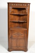A good Jacobean revival Ipswitch oak corner cabinet. Raised on squared legs with carved door