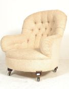 A 19th century Victorian mahogany upholstered armchair. Raised on brown ceramic castors to turned
