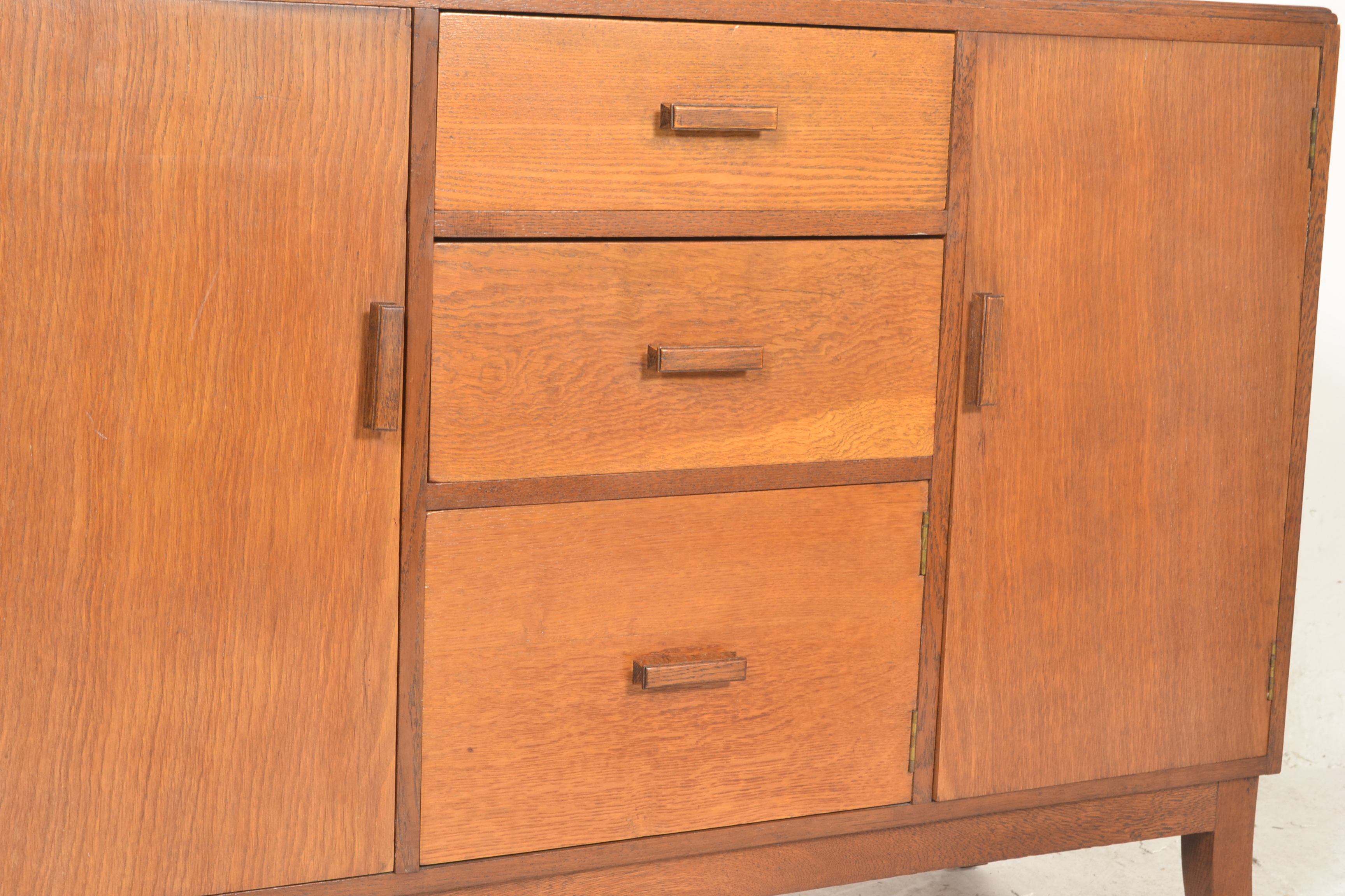 A mid 20th Century oak sideboard credenza having a central bank of three graduating drawers - Image 3 of 5