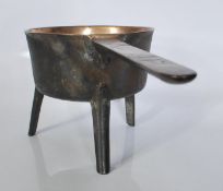 An 18th Century Georgian bronze skillet pan raised on three splayed tapering legs, having the handle