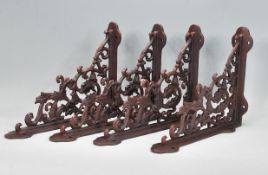 A set of four cast iron wall brackets having scrolled foliate decoration having a weathered / faux