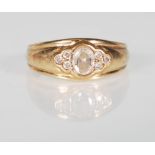 A 9ct yellow gold ladies ring set with a central white round faceted cut stone flanked by three