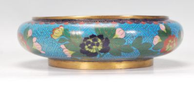 A Chinese Cloisonne dish of round form having a blue ground decorated with enamelled peonies and