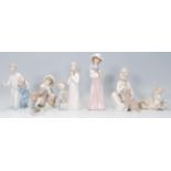 A group of four Lladro porcelain figures to include a young leaning on a log with a bird upon his