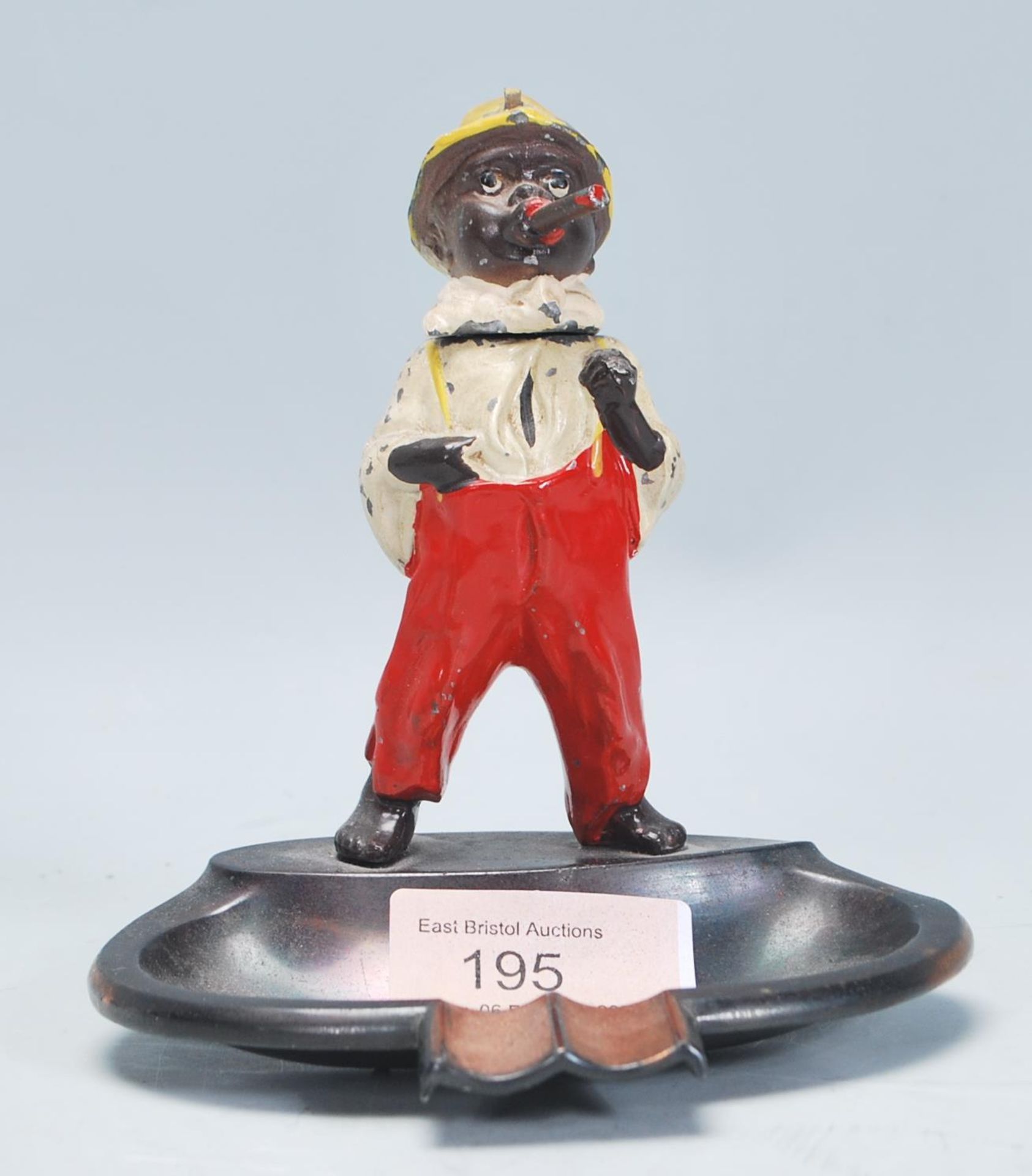 A vintage mid 20th Century novelty ashtray having a cold cast figurine of a boy smoking a cigar with