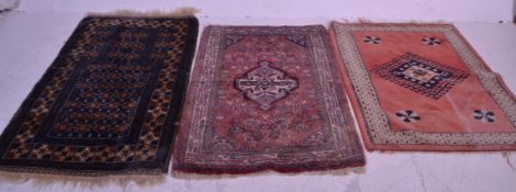 A group of three vintage 20th Century rugs to include a blue ground example having tasselled ends