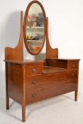 An Edwardian mahogany inlaid drop centre dressing table chest. Raised on square tapering legs with