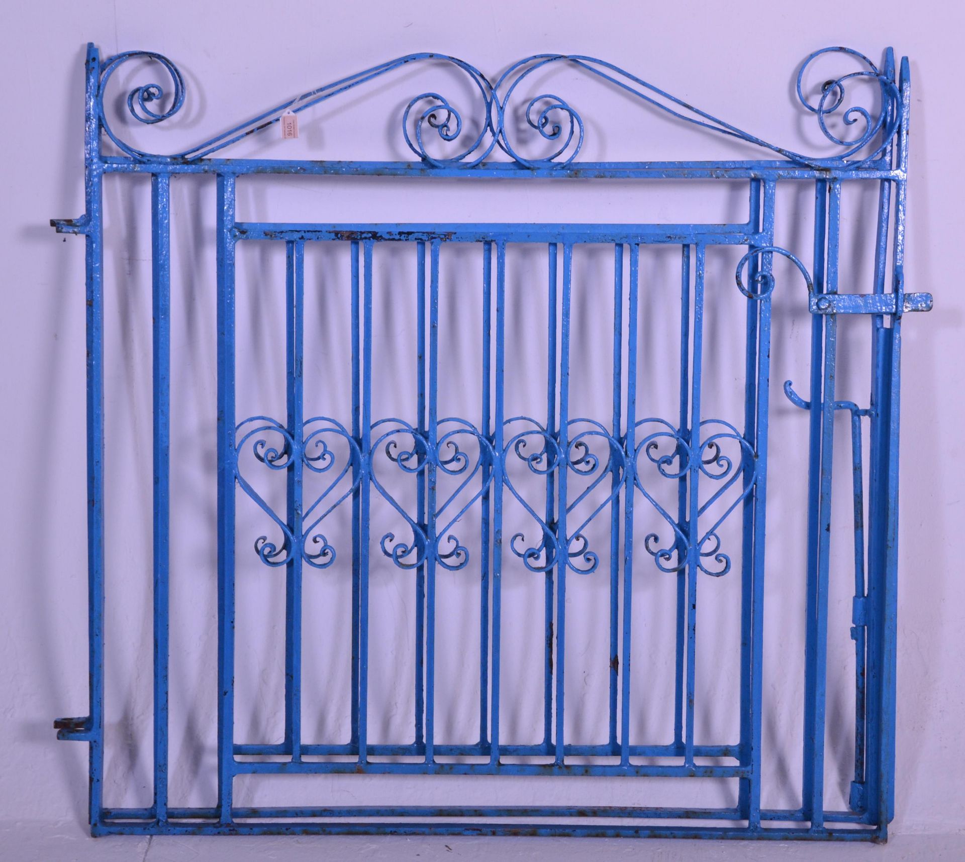 An early 20th Century 1930's iron twin door garden gate having scrolled details to the top, a square