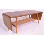 A retro 20th Century Ercol Golden Dawn beech and elm coffee table raised on tapering supports united