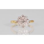 A hallmarked 18ct gold and diamond cluster ring set with nine round cut diamonds, one to centre with