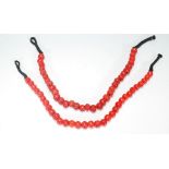 Two 20th Century red coral beaded necklace, each having large red beads on a string necklace, with
