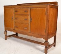 A 1930's Art Deco walnut sideboard credenza being raised on cup and cover legs united by stretchers.
