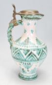 A 20th Century majolica jug of waisted form with a plaited design handle and pewter lid to the