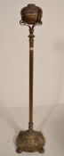 An early 20th Century brass free standing oil lamp stand having a central reeded column raised on