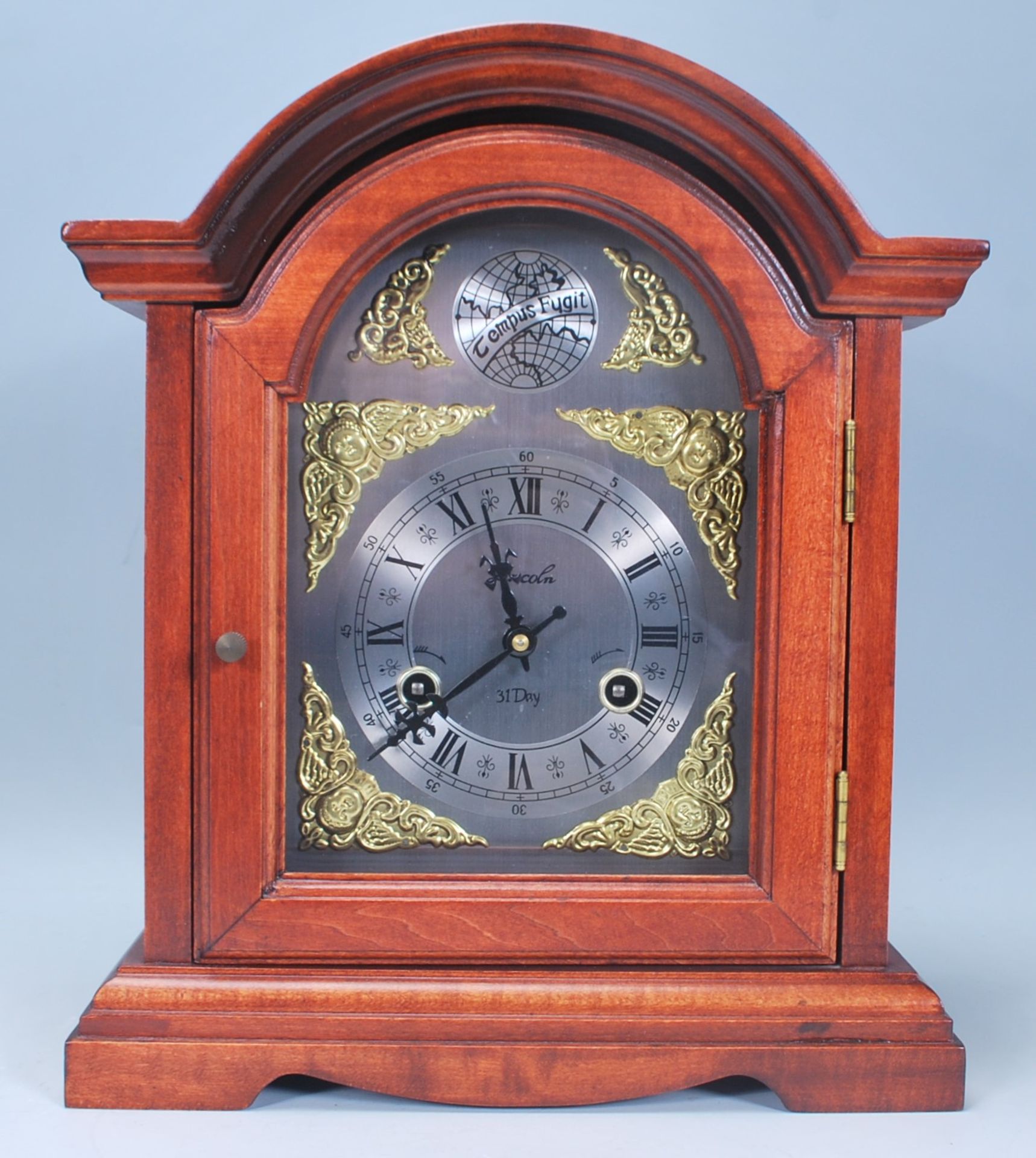 A vintage 20th Century antique style Tempus Fugit mantel clock having a wooden case with domed top