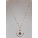 An early 20th Century 9ct gold open work pendant necklace, the pendant of circular form with a