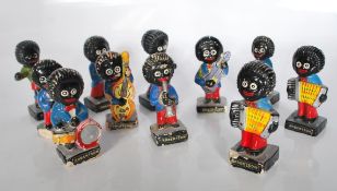 A group of nine vintage Robertson golly advertising band figurines along with two golly football