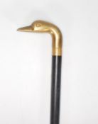 A vintage 20th Century walking stick cane having a tapering ebonise shaft with a cast brass handle