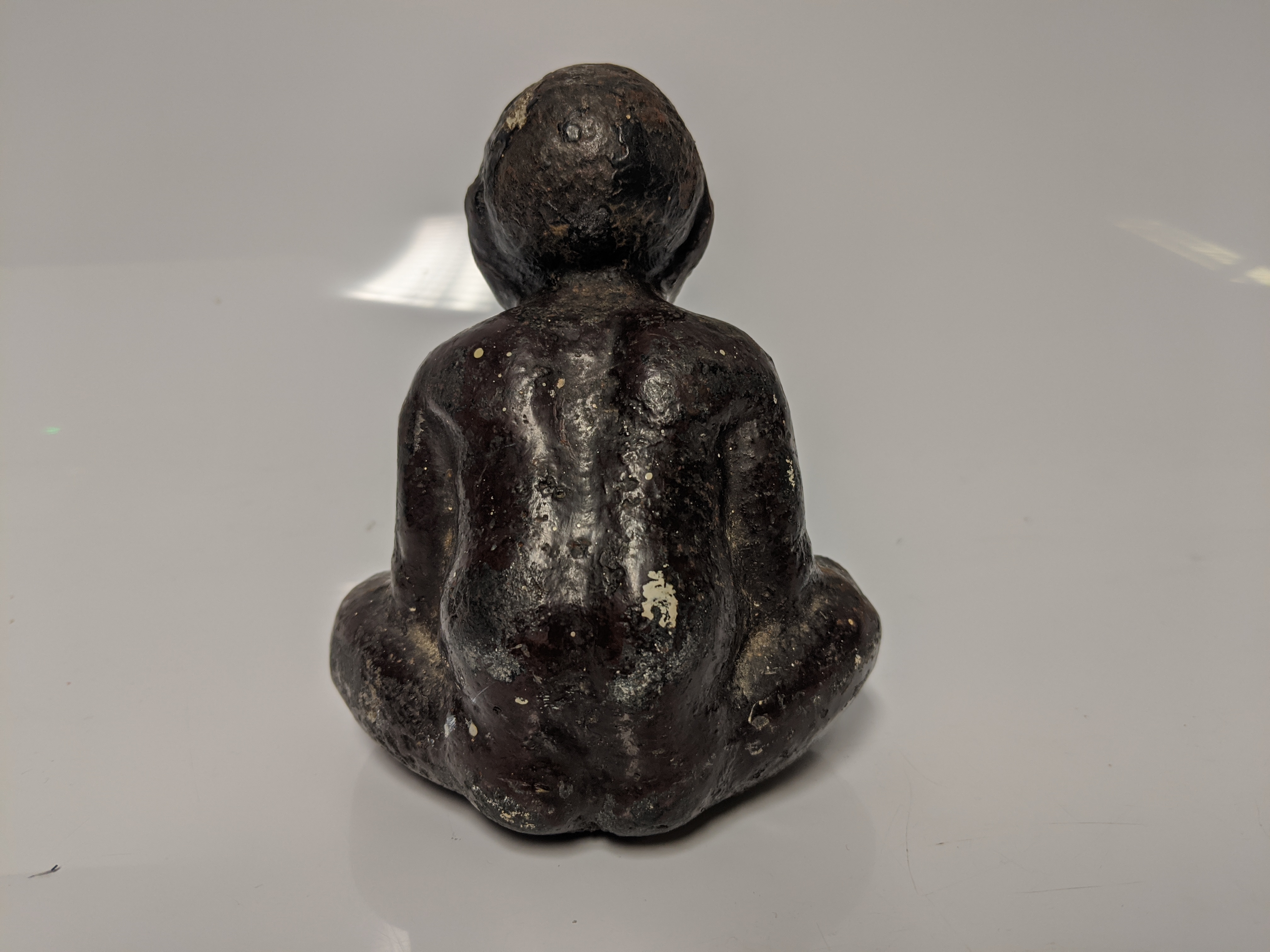 An early 20th century cast iron Black Americana paperweight / figurine of a seated male figure being - Image 3 of 5