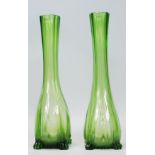 A pair of early 20th Century Art Deco green glass vases having slender necks with bulbous bases