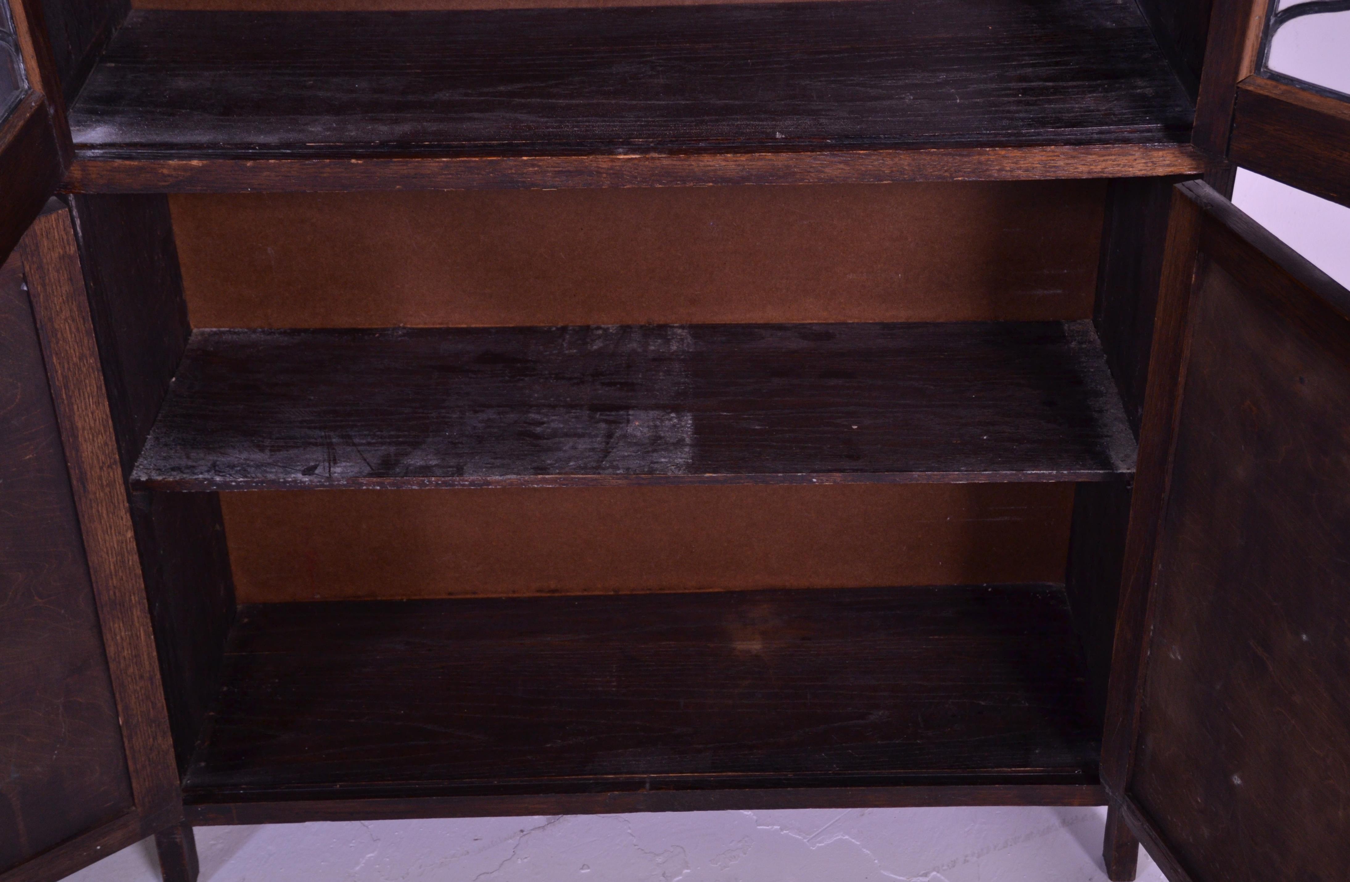 An early 20th Century 1920's oak bookcase having twin glazed lead lined glass doors over two oak - Image 5 of 5