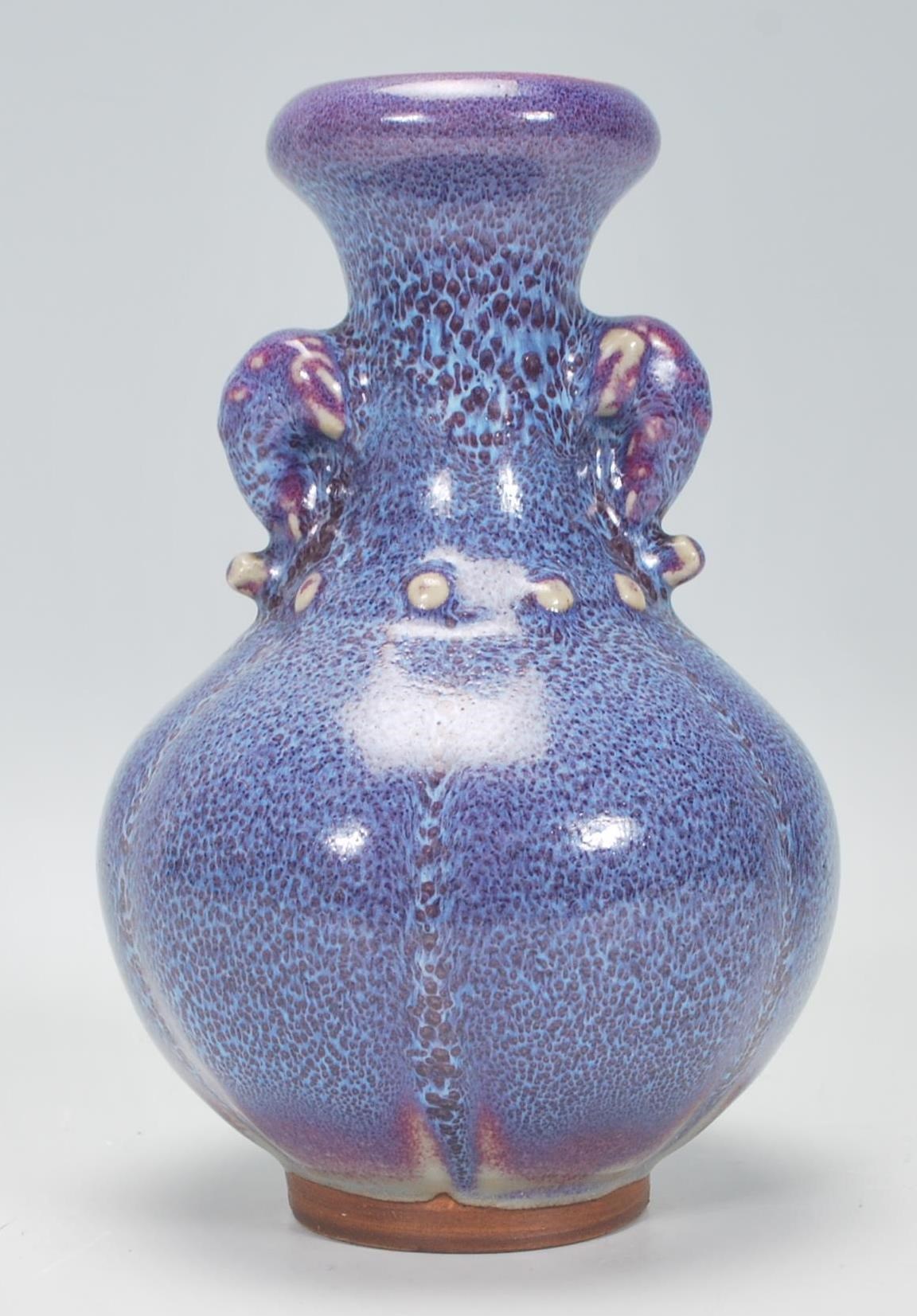 A Chinese earthenware / Jun ware style vase having a bulbous body with tapering neck and twin