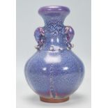 A Chinese earthenware / Jun ware style vase having a bulbous body with tapering neck and twin