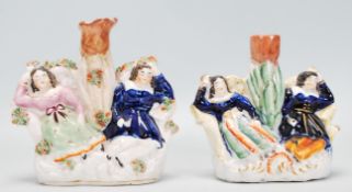 A pair of Staffordshire figurines / spill vases with each having two sleeping girls with one