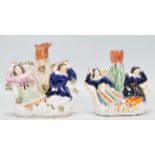 A pair of Staffordshire figurines / spill vases with each having two sleeping girls with one