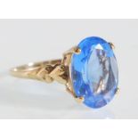 A hallmarked 9ct gold ladies dress ring prong set with an oval cut blue stone having heart