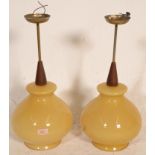 A pair of mid century teak wood and amber glass ce