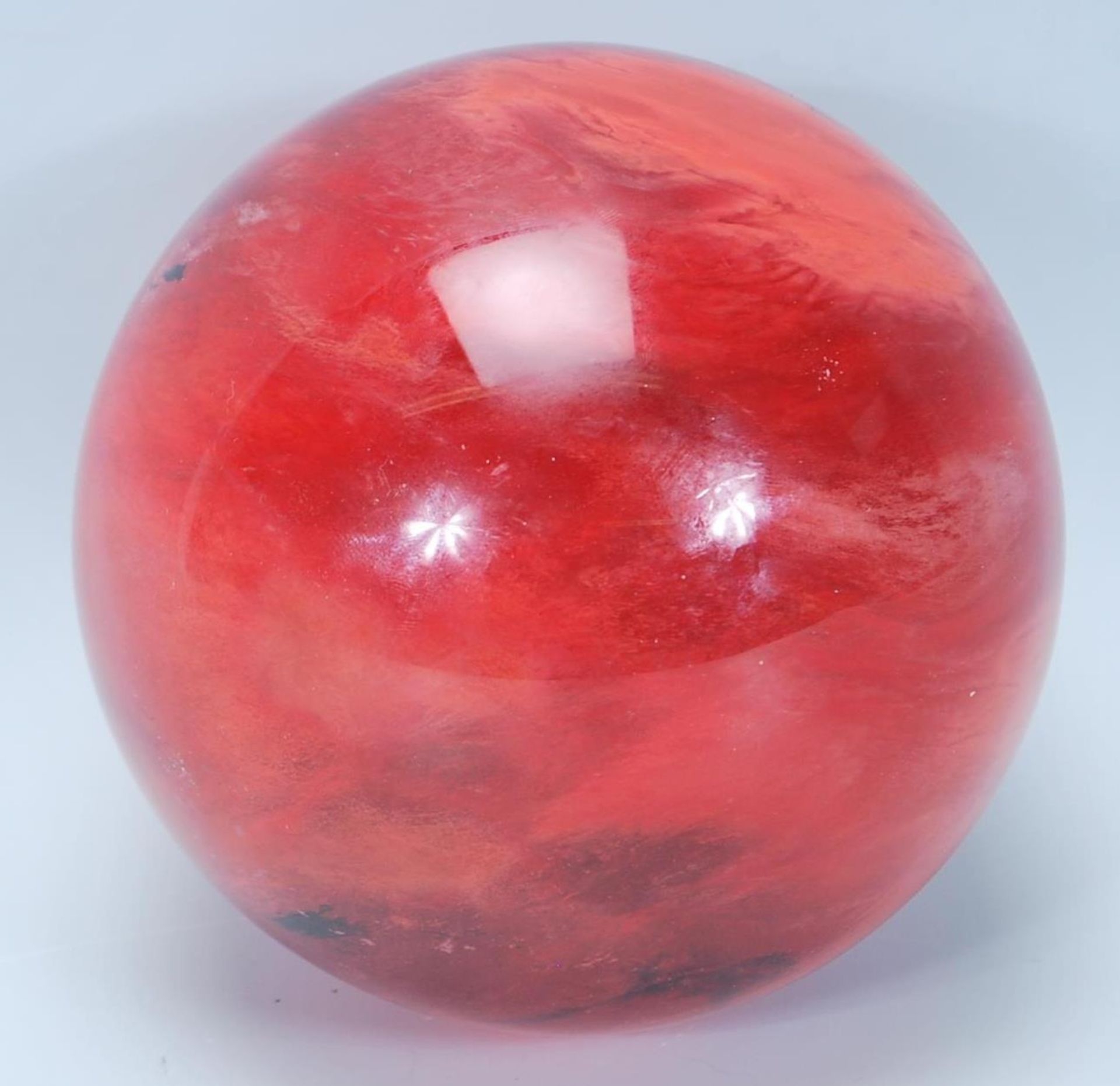 A vintage 20th Century heavy red glass witch type ball / decorative orb with swirl decoration within