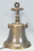 A contemporary novelty brass ships bell / front door bell attached to an anchor backplate fixing.