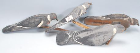 A group of four vintage hunting / shooting interest pigeon decoys having painted and shaped bodies