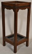 An early 20th Century oak stick stand of rectangular form with carved bobin top raised on four